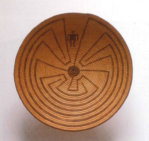 Brown woven basket with a tribal design. The design depicts a man going through a maze.