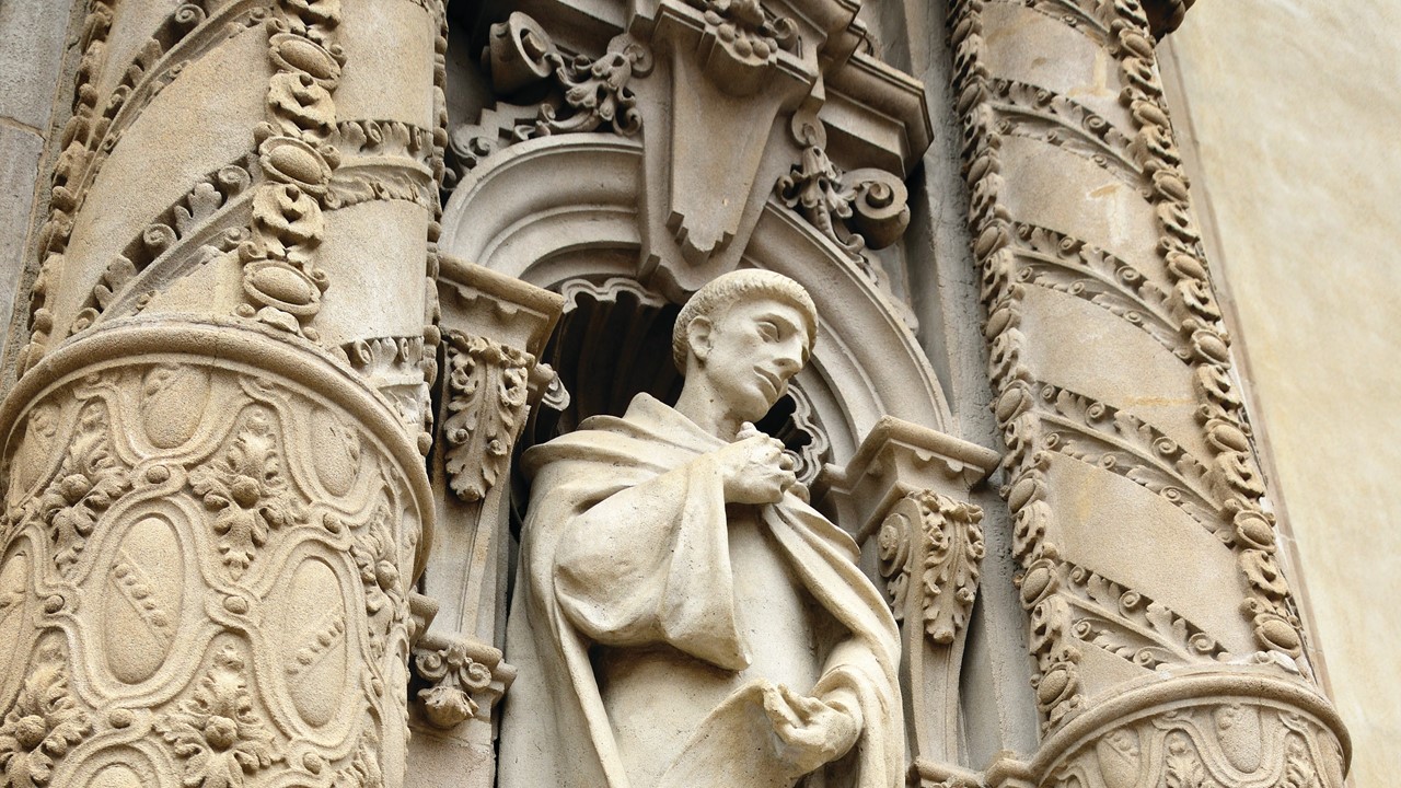 A marble sculpture of a monk on the museum's facade.