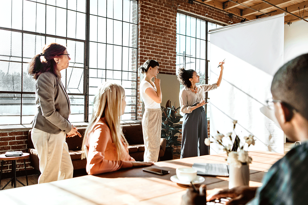 group of people writing on a white board