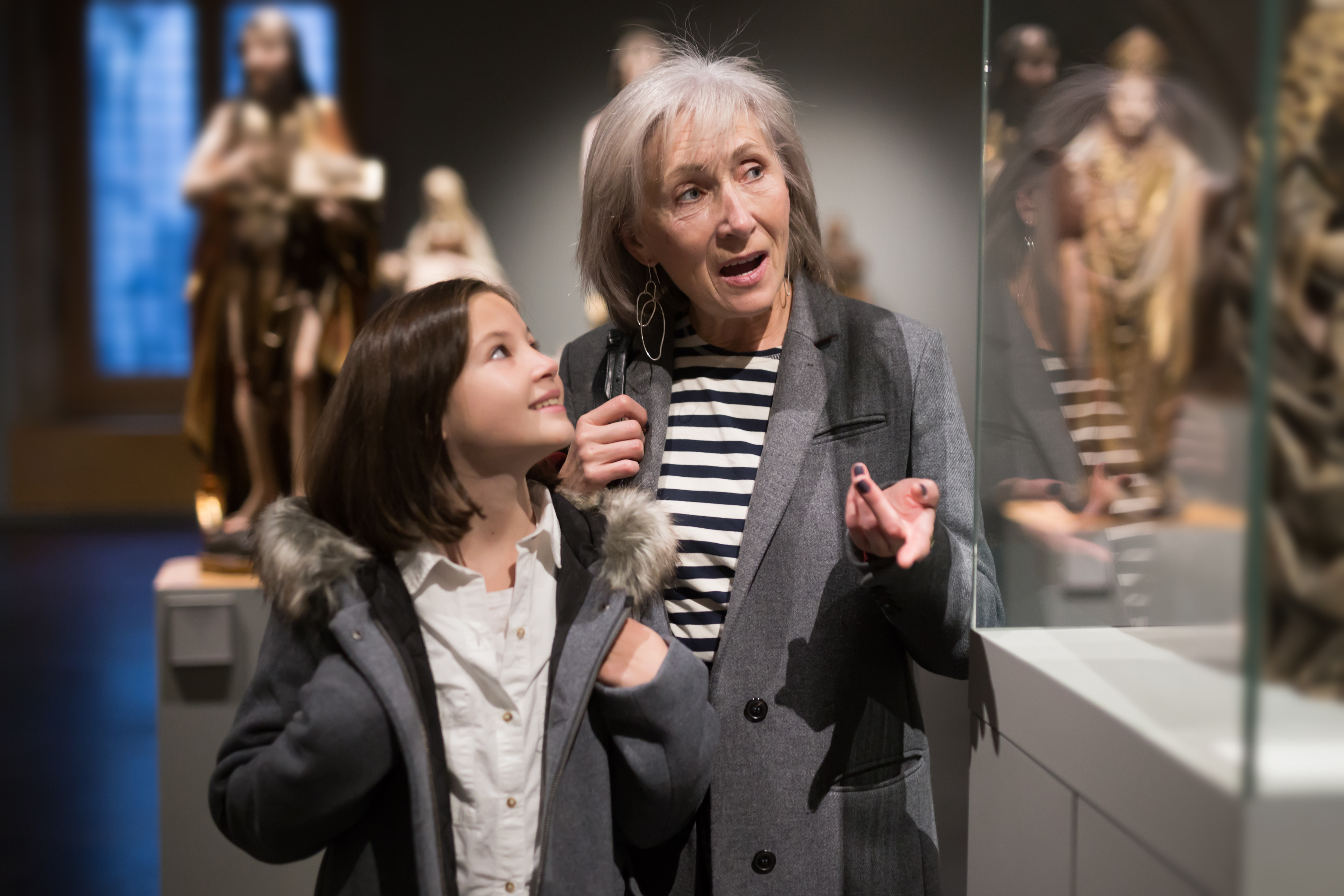 An adult and child looking at a glass case