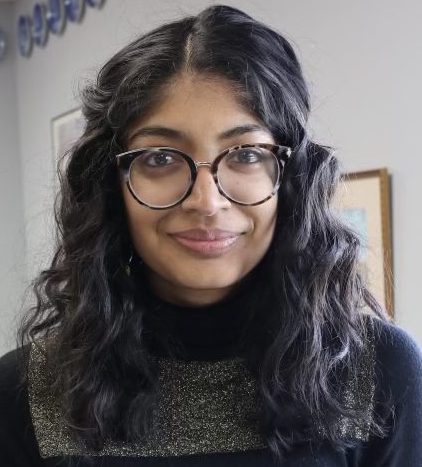 Female, with glasses, dark long hair and dark shirt