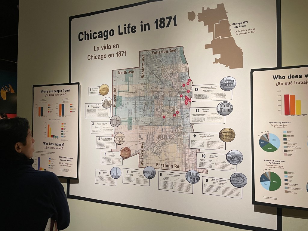 A person looking at a labeled map reading "Chicago Life in 1871," with text in both English and Spanish.