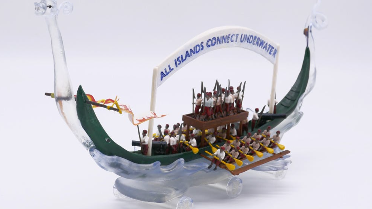 A toy boat with lots of people and oars.