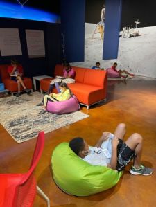 Children sit in beanbags in a sitting area at the museum. 