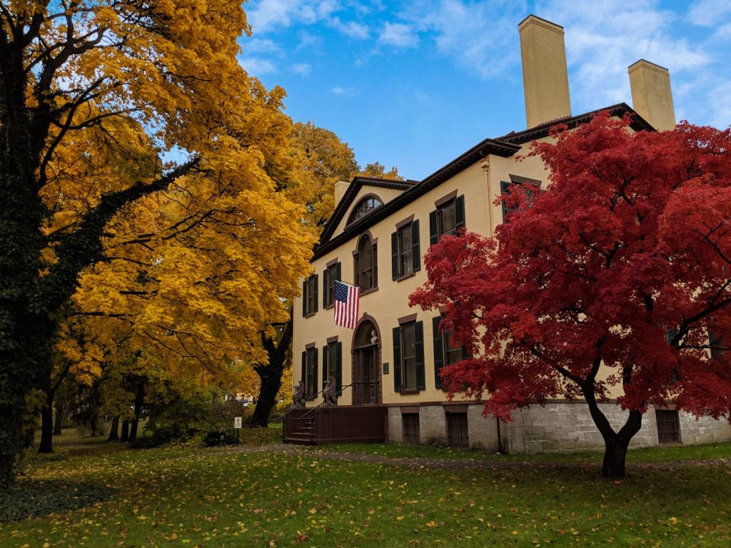 An exterior shot of the museum with autumn leaves on several trees.