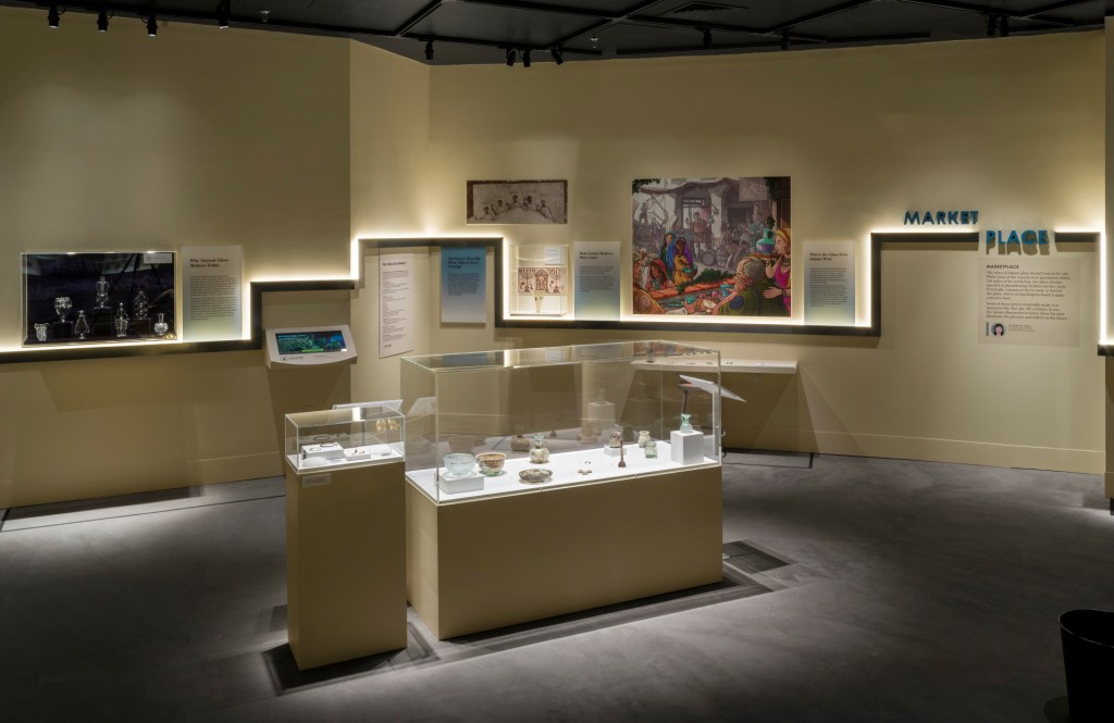 A room in the exhibition with cased objects in the center and a timeline on the wall behind. 