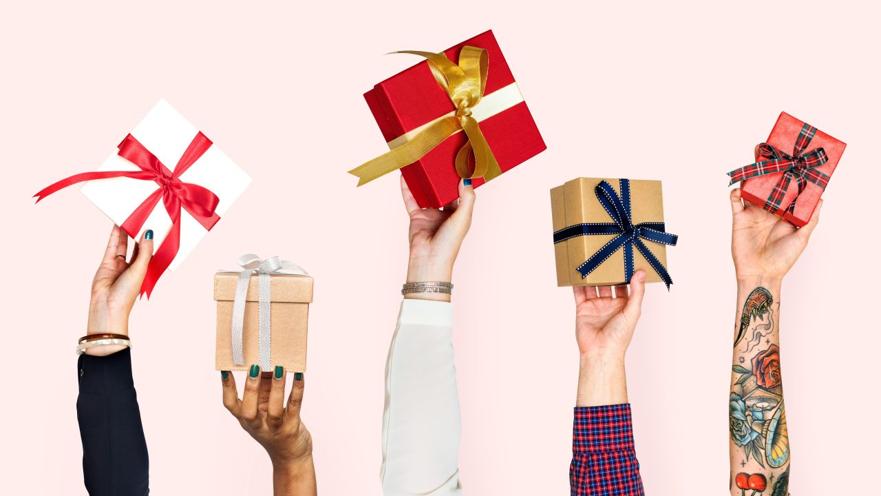 A row of people holding up wrapped gift boxes with varied colored ribbons tied to them